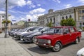 Old red car on the Constitution Square in Kharkiv Ukraine, close-up. A row of cars parked on the street against the background