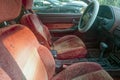 The red velour front bucket seats and dashboard in the interior of an abandoned car in a junkyard Royalty Free Stock Photo