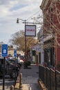 The Red Velvet Bistro along a red brick sidewalk with other shops and restaurants with cars parked along the street Royalty Free Stock Photo