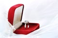 A red velvet box with an engagement, engagement ring in white gold and precious stones lies on a white veil. Love. Creation of a Royalty Free Stock Photo