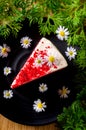 Red velvet cake on black color plate for celebrations and put on wooden table, Decorated with white and green flowers Royalty Free Stock Photo