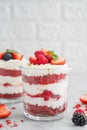 Red Velvet cake trifle with fresh berries in a glass jar on a gray concrete background. Dessert for Valentine`s Day. Copy space Royalty Free Stock Photo