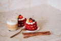 Red velvet cakes, portioned, decorated with cherries and strawberries. transparent mug of cappuccino with a cinnamon stick. delici Royalty Free Stock Photo