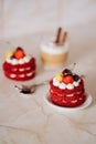 red velvet cakes, portioned, decorated with cherries and strawberries. transparent mug of cappuccino with a cinnamon stick. delici Royalty Free Stock Photo