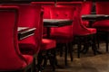 Red velvet chairs and black tables