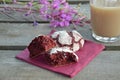 Red velvet cookies next to a cup of coffee. sunny spring or summer morning. pink purple flower Royalty Free Stock Photo