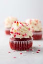 Red velvet cupcake with cream cheese frosting and red hearts sprinkles on the top. Valentine\'s Day concept. Royalty Free Stock Photo