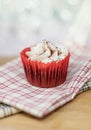 Red velvet cupcake on a wooden surface with a shallow depth of field and bokeh background Royalty Free Stock Photo