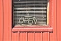 Open sign in morning light of dark window