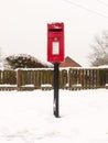 red village post box outside street village with snow winter Royalty Free Stock Photo