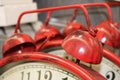 Red vintage alarm clock ringer element on the background of others of the same.