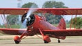 Red vintage biplane with radial engine and propeller rotating