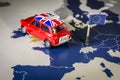 Red vintage car with Union Jack flag and brexit or bye words over an UE map and flag. Royalty Free Stock Photo