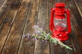 Red vintage kerosene lamp, and lavender flowers on wooden table. fine art concept.