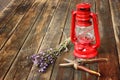 Red vintage kerosene lamp, and sage flowers on wooden table. fine art concept.