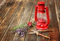 Red vintage kerosene lamp, and sage flowers on wooden table. fine art concept.