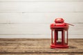 Red vintage lamp, a candlestick stands on a wooden table. Royalty Free Stock Photo