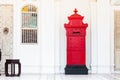 Red and vintage postbox in front of an old building