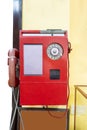 Red vintage public pay phone on yellow background