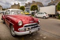 A red vintage shiny beautiful Chevrolet Bel Air in the street of a small city in France