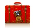 Red vintage threadbare suitcase with a retro photo camera