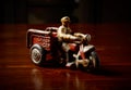 Red vintage toy tricycle on dark wooden table Royalty Free Stock Photo