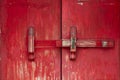 Red vintage wooden door made to plank peeling paint and large locked old wooden with padlock rusty Royalty Free Stock Photo