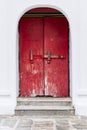 Red vintage wooden door made to plank peeling paint and large locked old wooden with padlock rusty Royalty Free Stock Photo