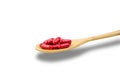 Red vitamins and supplements capsule on wooden spoon on white background with clipping path and copy space for text. Royalty Free Stock Photo