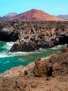 Red volcano close to wild sea cliffs Royalty Free Stock Photo