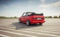 red Volkswagen Golf cabriolet on a big parking lot