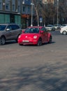 Red Volkswagen New Beetle car parked in a street of the city Royalty Free Stock Photo