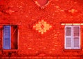 Red wall and colored shutters Royalty Free Stock Photo