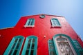 Red wall house and Green windows on the street. Red house with green door. Green window, door on a red wall of a modern house in Royalty Free Stock Photo