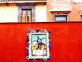 Red wall with religious art in front of historic vintage buildings in san miguel allende Mexico Royalty Free Stock Photo