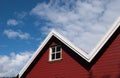 Red wall and roof of a house. One window with white details Royalty Free Stock Photo