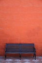 Red wall with vintage bench. Royalty Free Stock Photo