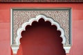 A red wall with a white archway