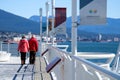 elderly men and woman in windy weather walking along Canada Place Vancouver city center look at Pacific ocean mountains