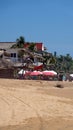 Red flag in front of a beach bar with shade umbrellas Royalty Free Stock Photo