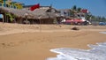 Red flag in front of a beach bar with shade umbrellas Royalty Free Stock Photo