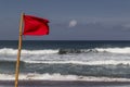 Red warning flag flapping in the wind on beach at stormy weather Royalty Free Stock Photo