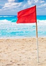 Red warning flag on a stormy beach Royalty Free Stock Photo