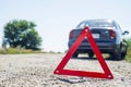 Red warning triangle with a broken down car. Red emergency stop sign and broken car on the road Royalty Free Stock Photo