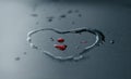 Red water drops and heart shape on dark background, soft focus Royalty Free Stock Photo