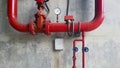 Red water or gas pipeline with gate pressure valve and stainless steel test box installed on concrete wall with copy space. Royalty Free Stock Photo