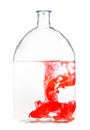 Red watercolour dissolves in water in glass flask Royalty Free Stock Photo