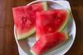 Red watermelon cut into triangles, on a white plate
