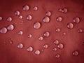Red waterproof fabric with large raindrops close-up Royalty Free Stock Photo