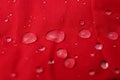 Red waterproof fabric with drops as background, closeup Royalty Free Stock Photo